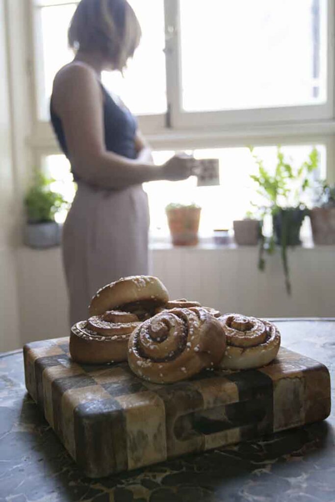 Can You Bake In An Air Fryer? A stack of freshly baked cinnamon rolls resting on a cutting board.