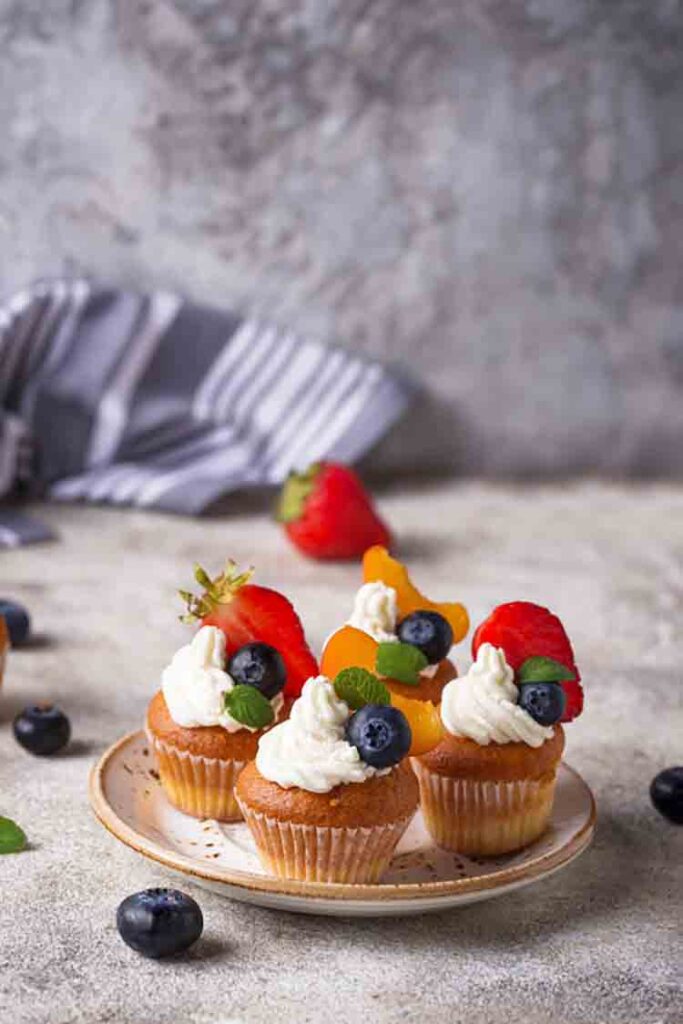 Cupcakes with cream and berries. Sweets for summer party