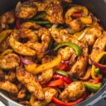 Air Fryer Chicken Fajitas - Chicken sitting in an air fryer basket. One of many recipes in this guide to the best keto air fryer recipes.
