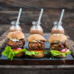 Air fryer meatloaf sliders sit lined up on a plate.